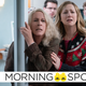 Jamie Lee Curtis' Laurie Strode (center) leans on a hospital doorway as a crowd looks concerned.